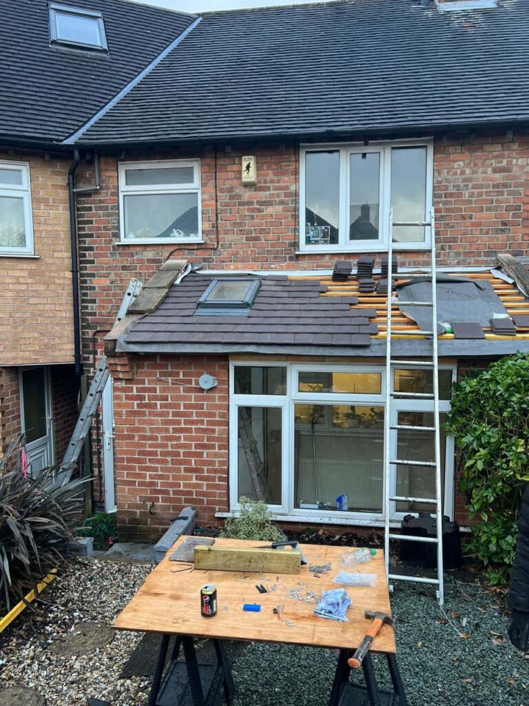 This is a photo of a roof extension that is having new roof tiles installed. This is a photo taken from the roof ridge looking down a tiled pitched roof on to a flat roof. Works carried out by Bolsover Roofing Repairs