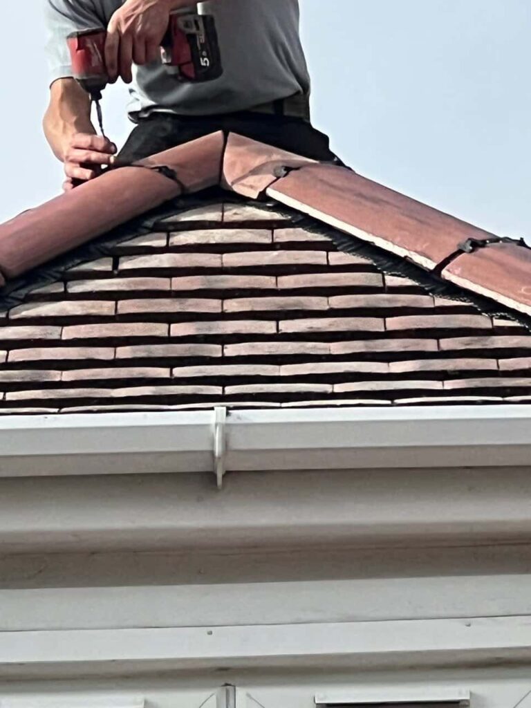 This is a photo of one of the operatives of Bolsover Roofing Repairs installing new ridge tiles