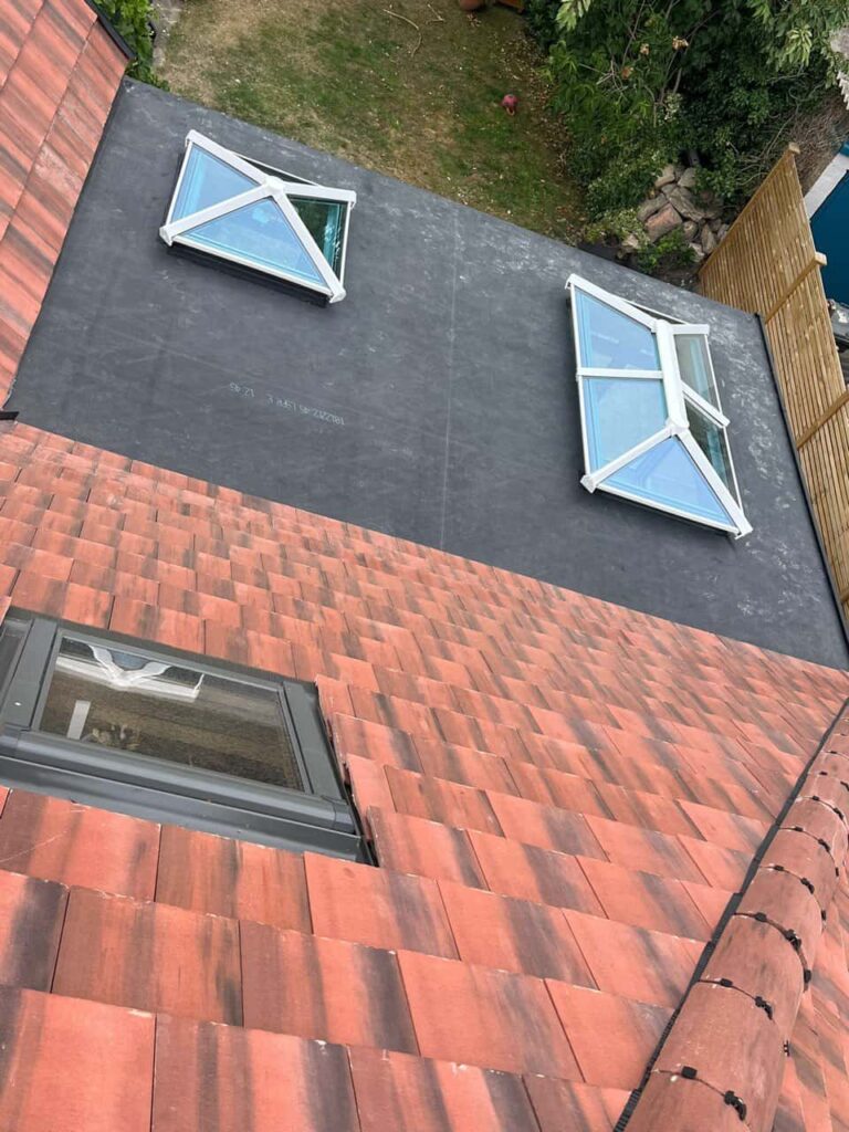 This is a photo taken from the roof ridge looking down a tiled pitched roof on to a flat roof. Works carried out by Bolsover Roofing Repairs